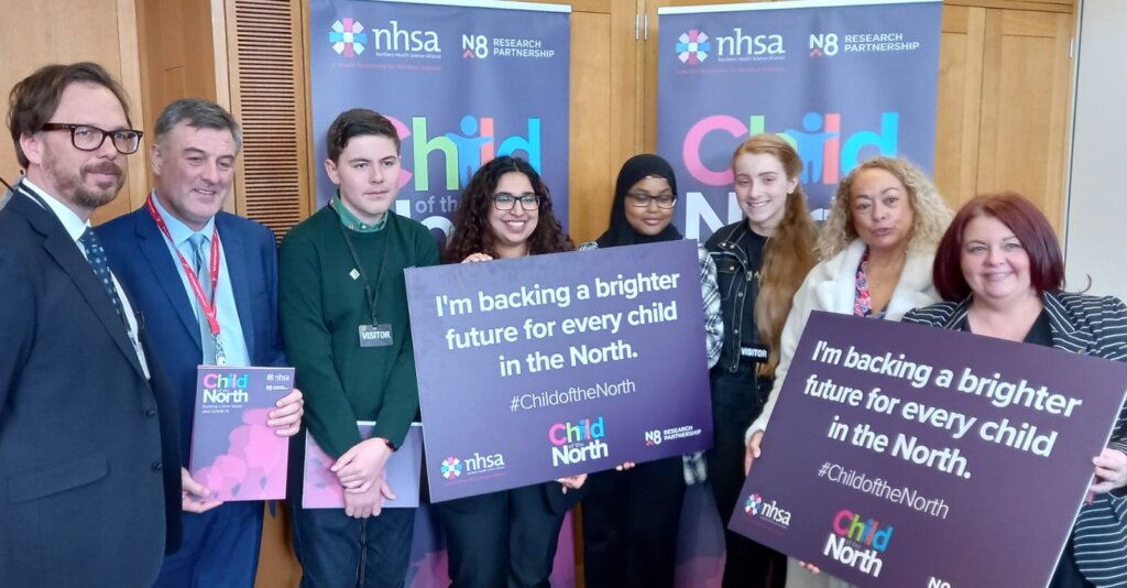 Event attendees hold up pledge cards to show their support for children in the North